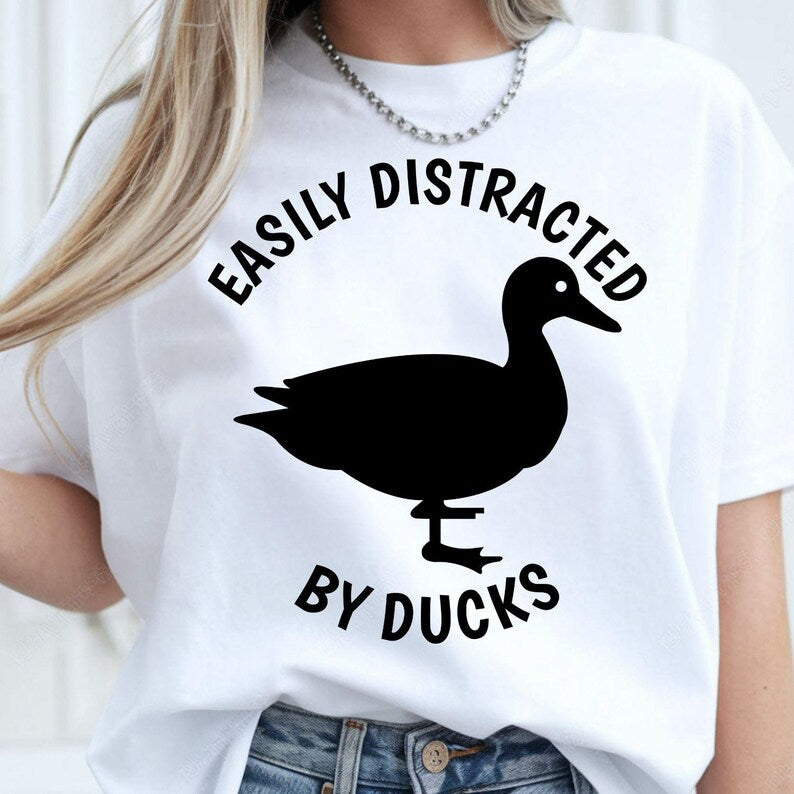 Easily Distracted by Ducks shirt, funny duck lover t shirt, bird lover tee, duck graphic shirt, wildlife apparel, waterfowl t shirt, pond lover clothing, nature enthusiast gift, animal lover tee and novelty bird fashion. Every premium shirt is proudly printed in the UK by TeezoraPrints for everyday comfort, durability and professional print quality.
