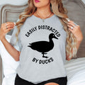 Perfect for bird watching, nature walks, countryside holidays, lake visits, wildlife parks, outdoor adventures, animal events and casual everyday wear. This Easily Distracted by Ducks shirt combines humour, comfort and style, while every premium t-shirt is professionally printed in the UK by TeezoraPrints using high-quality materials.