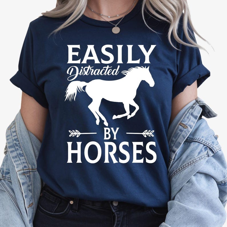 Easily Distracted by Horses shirt, funny horse lover t shirt, equestrian tee, horse riding shirt, western graphic tee, stable apparel, horse enthusiast clothing, equine lover gift, ranch style shirt, country life fashion and premium casual wear. Every premium shirt is proudly printed in the UK by TeezoraPrints for comfort and durability.