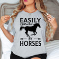 Searching for the perfect gift for a horse lover? This Easily Distracted by Horses shirt is an excellent choice for birthdays, Christmas, Mother's Day, Father's Day or any special occasion. Featuring a bold horse silhouette and humorous slogan, every premium shirt is professionally printed in the UK by TeezoraPrints for a memorable gift they'll love.
