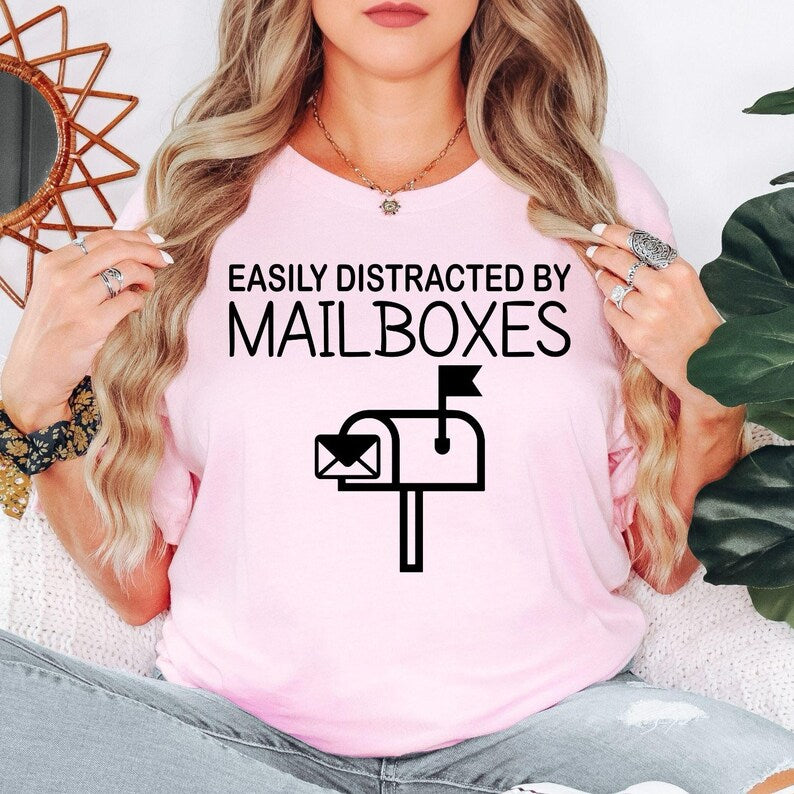Funny mailbox lover shirt designed for postal employees, mail carriers, delivery workers, mailbox collectors and novelty clothing fans. Perfect for work, post office visits, delivery routes, casual weekends and everyday outfits. Every premium graphic t-shirt is professionally printed in the UK by TeezoraPrints, offering vibrant print quality and lasting comfort.