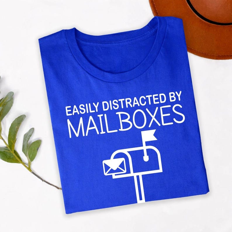 Perfect for delivery routes, post office work, employee appreciation events, retirement parties, casual Fridays, work celebrations, everyday wear and weekend outings. This Easily Distracted by Mailboxes shirt combines humour, comfort and style, while every premium t-shirt is professionally printed in the UK by TeezoraPrints using premium-quality materials.