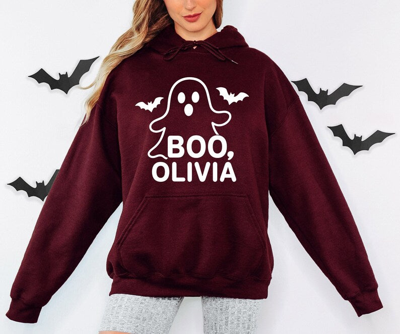 Personalised ghost Halloween sweatshirt featuring the wording Boo followed by a custom name, cute bat decorations and a fun spooky design, ideal for Halloween outfits, trick or treat adventures, Halloween parties, autumn gatherings and personalised gifts.