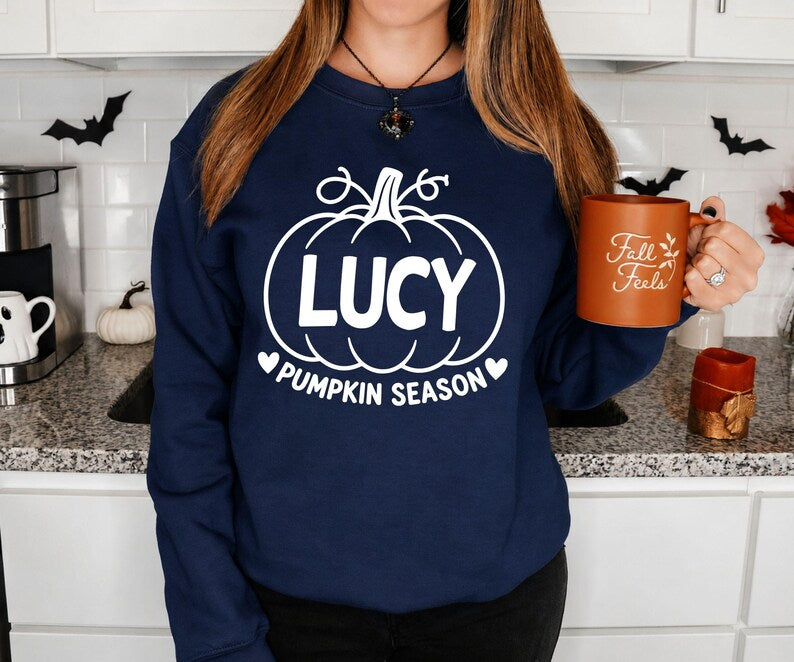 Personalised autumn sweatshirt with a chosen name displayed inside a pumpkin illustration and Pumpkin Season wording. Ideal for wearing during pumpkin picking, Halloween parties, autumn walks, family gatherings and seasonal photoshoots. This custom sweatshirt offers a fun way to celebrate the season and makes a memorable personalised gift for friends, family members and pumpkin enthusiasts.